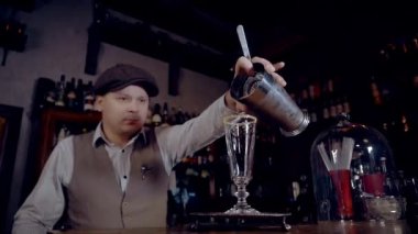 The bartender pours the finished Smoking Gun Sour cocktail, pouring it into a sour glass. Forward movement of the camera.  The footage is recorded at 60 frames per second, and you can slow it down. 