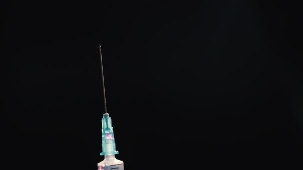 Une main dans un gant médical bleu tient une seringue injectable. Éteint les bulles d'air. Vérification de la seringue, du jet de drogue .