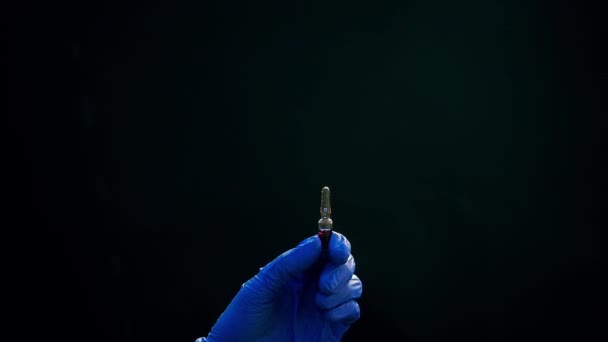 Una mano in un guanto medico blu tiene una siringa per iniezione. Toglie bolle d'aria. Controllando la siringa, il jet della droga . — Video Stock