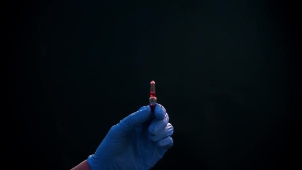 青い医療用手袋の手は注射用注射器を保持しています。気泡がオフになります。注射器と薬のジェットを調べて. — ストック動画