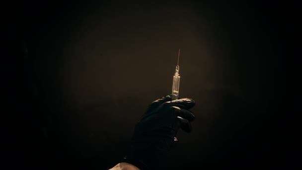 A hand in a blue medical glove holds a syringe for injection. Shakes off air bubbles. Checking the syringe,the drug jet. — Stock Video