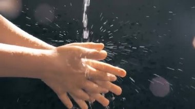 Bir su akıntısı altında çocukların elleri. Güneş spreyi. Çocuk ellerini yıkar..