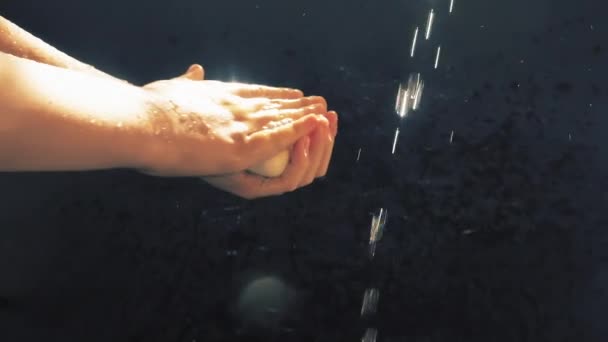 Kinderen handen onder een stroom van water. Zonnestraal. Het kind wast zijn handen.. — Stockvideo