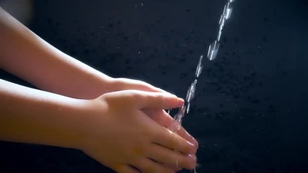 Kinderen handen onder een stroom van water. Zonnestraal. Het kind wast zijn handen.. — Stockvideo