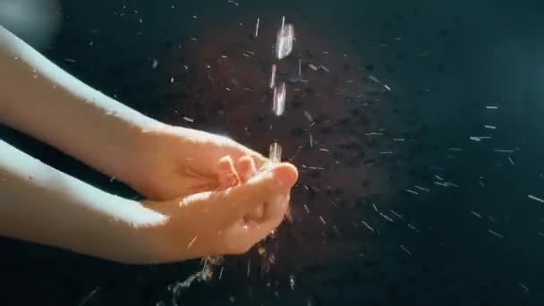 Barnens händer under en ström av vatten. Solsprayen. Barnet tvättar händerna. — Stockvideo