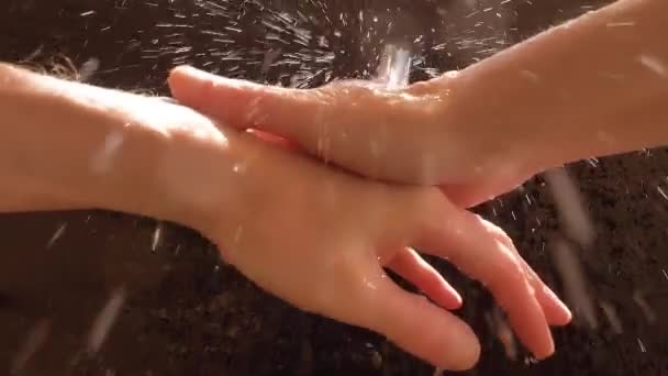 Ένας λευκός πλένει τα χέρια του κάτω από ένα ρυάκι νερό. Ψεκασμός σταγονιδίων νερού αργής κίνησης. — Αρχείο Βίντεο