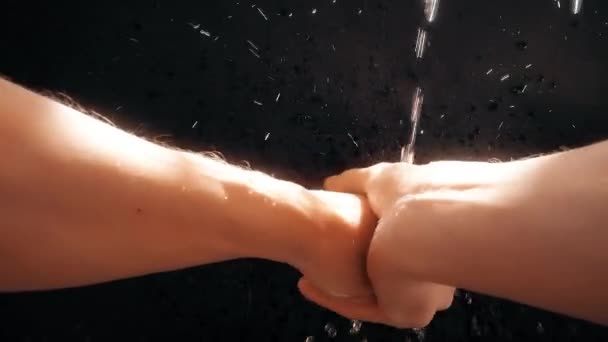 Ein Mann aus dem Kaukasus wäscht sich unter einem Wasserstrom die Hände. Wassertröpfchen in Zeitlupe versprühen. — Stockvideo