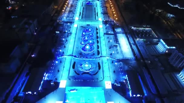 Una vista panorámica de la ciudad de invierno. La gente monta en patines. Fondo fantástico para juegos y películas. Noche. — Vídeos de Stock