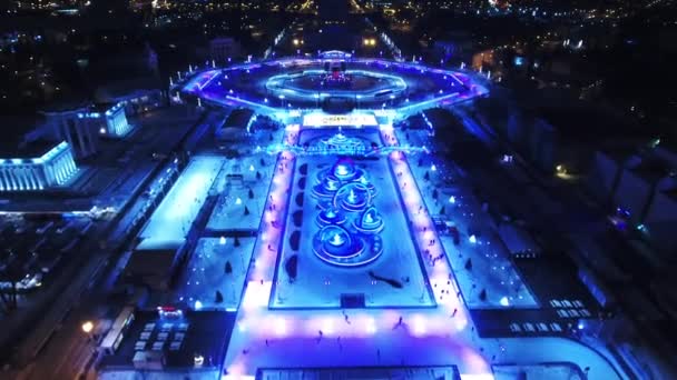 Una vista panorámica de la ciudad de invierno. La gente monta en patines. Fondo fantástico para juegos y películas. Noche. — Vídeos de Stock