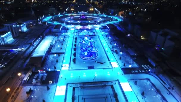 Una vista panorámica de la ciudad de invierno. La gente monta en patines. Fondo fantástico para juegos y películas. Noche. — Vídeo de stock