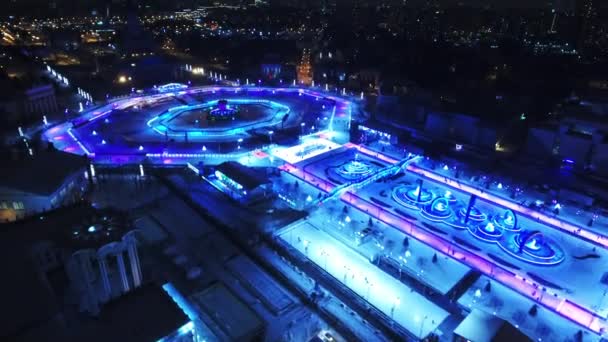 A birds-eye view of the winter city. People ride on skates. Fantastic background for games and movies. Night — Stock Video