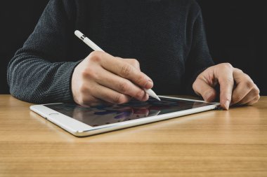 zmir, Türkiye - 30 Ocak 2020: Apple kalem ve Ipad Pro ile resim çizen bir adam