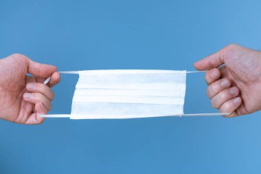 Mavi arka planda beyaz tıbbi koruyucu maske.