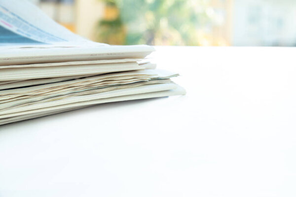 Pile of fresh morning newspapers on the table at office. Folded and stacked journals