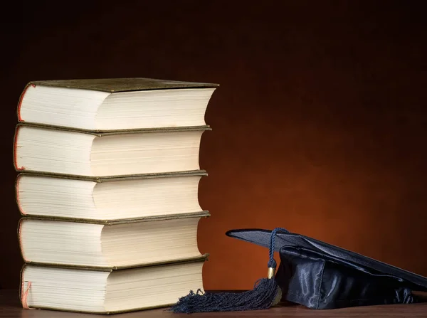Stack of books and graduation cap Stock Photo