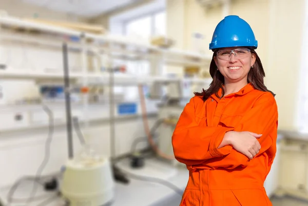 Woman worker in orange overall and blue safety helmet isolated on white background