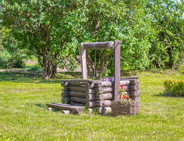 Hölzerner Brunnen Auf Grünem Rasen Mit Blumen — Stockfoto