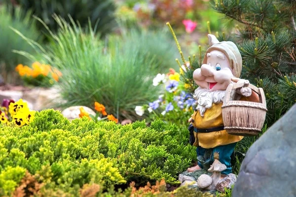 ニースの花の間に立っておかしい庭のノーム — ストック写真