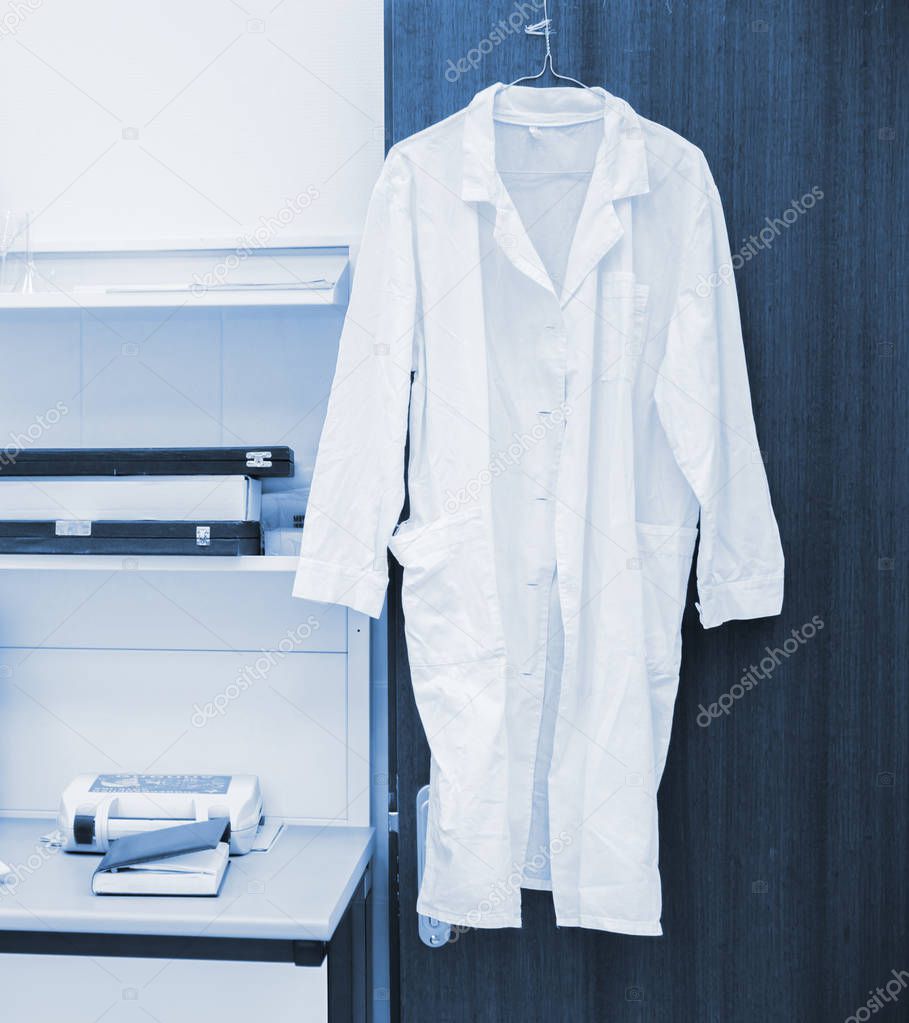 white robe hanging on a door in laboratory