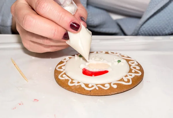 Girl painting christmas gingerbread in art studio with sweet icing