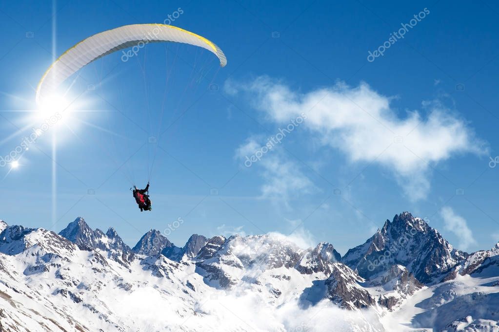 Paragliding in the mountains high up in the blue sky