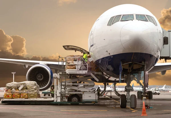 Laden van lading in het vliegtuig op luchthaven, bekijken via venster — Stockfoto