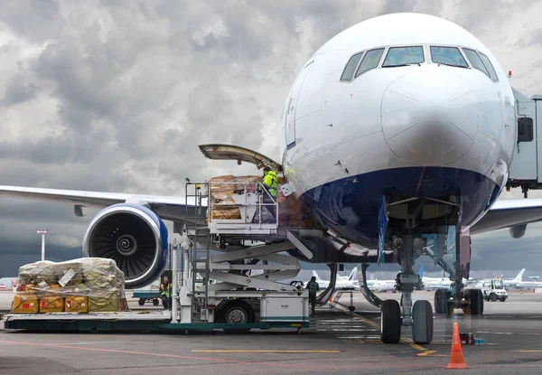 Naložení nákladu do letadla na letišti, zobrazit přes okno — Stock fotografie
