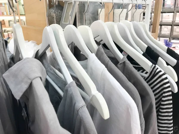 gray tone linen clothes hanging on a rack in a designer clothes store