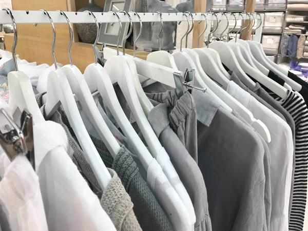 gray tone linen clothes hanging on a rack in a designer clothes store