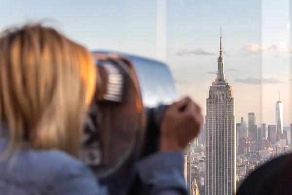 New york, États-Unis - 17 mai 2019 : New york, États-Unis - 17 mai 2019 : Vue arrière d'une femme qui regarde à travers des jumelles à l'Empire State Building de New York — Photo