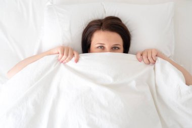 Portrait of young beautiful woman in bed