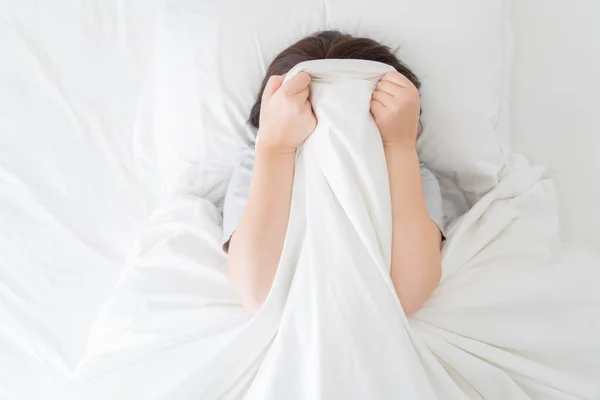 Genç bir kadın yatağında yüzünü gizliyor. — Stok fotoğraf