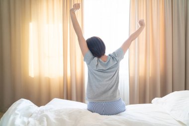 Güzel rüyalardan sonra rahat bir yatakta uzanan kadın.