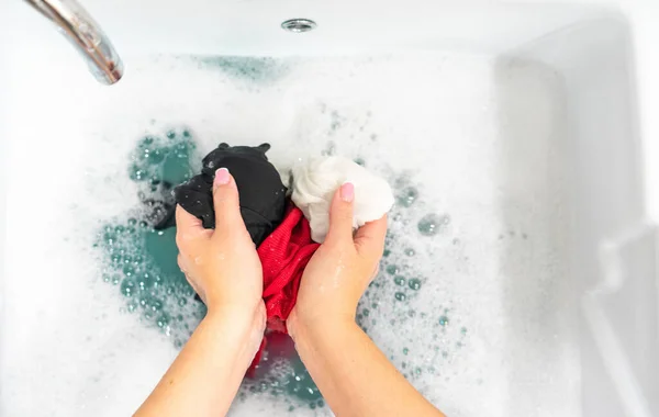 Waschbecken mit Händewaschen unterschiedlich gefärbter Kleidung — Stockfoto