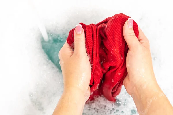 Mujeres lavando las manos ropa de color rojo brillante —  Fotos de Stock