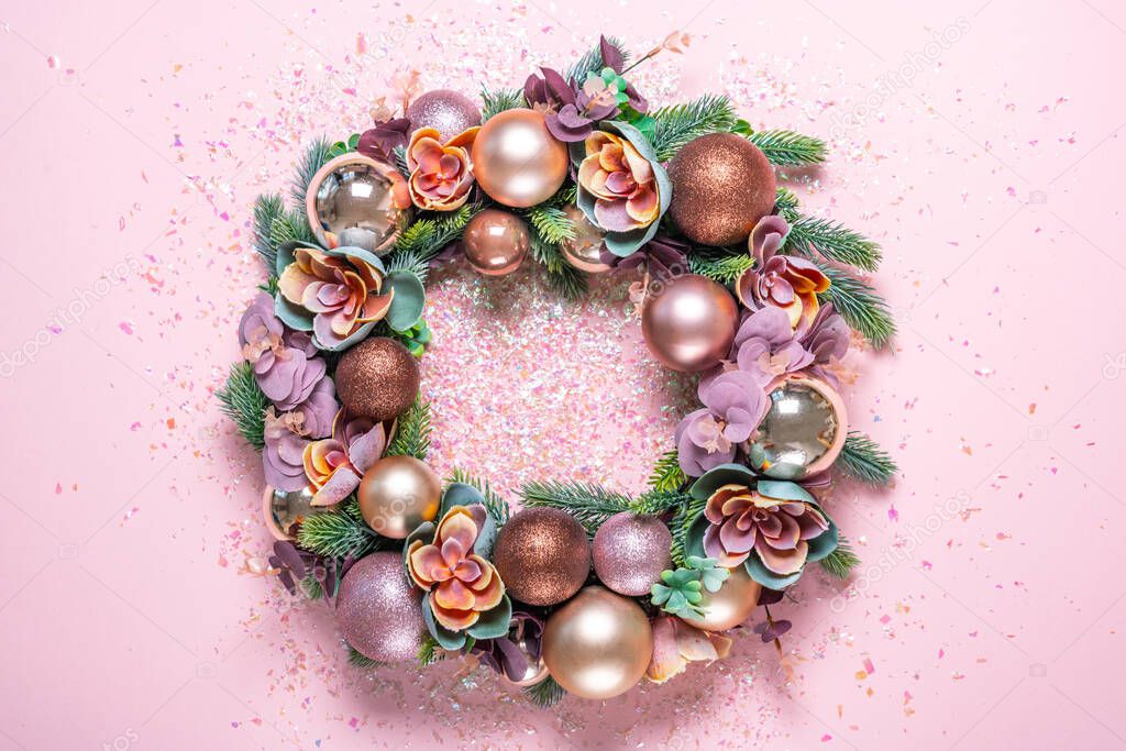 Christmas wreath decoration on pink background. flat lay
