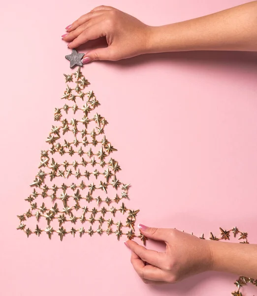 Weibliche Hände schmücken den Weihnachtsbaum auf rosa, Blick von oben. Flache Lage — Stockfoto