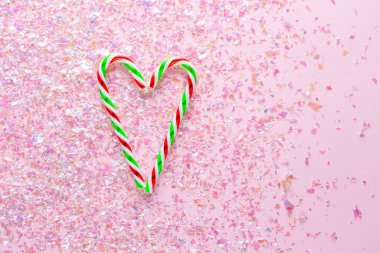 Pembe arka planda kalp şeklinde iki lolipop. Yeni yıl ve Noel hediyeleri. en üstteki görünüm