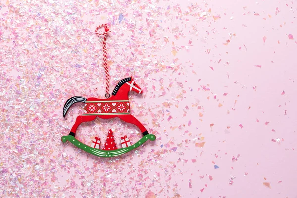 Árvore de Natal brinquedo de madeira de cavalo de balanço no fundo rosa com brilho. Colocação plana, vista superior de com espaço de cópia — Fotografia de Stock