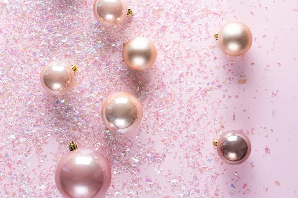 Decoração de Natal de muitas bolas no fundo rosa com brilho brilhante. Deitado plano, vista superior — Fotografia de Stock