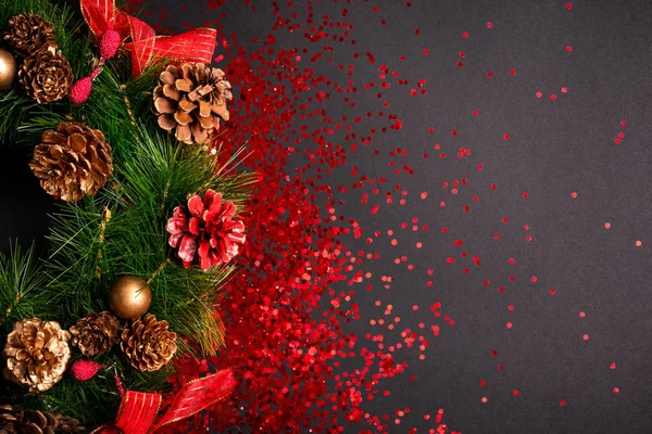 Рождественский венок с красным блеском на черном фоне, плоский лежал с копировальным местом — стоковое фото