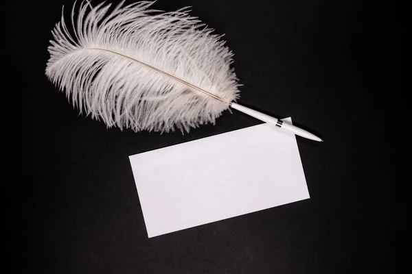 White empty envelope with retro feather pen on black background — Stock Photo, Image