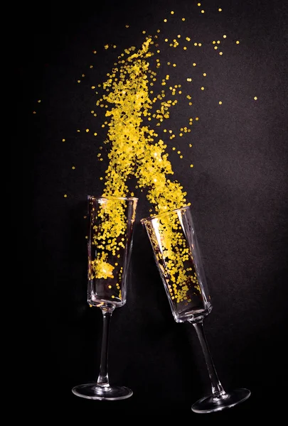 Två glas med gul tinsel på svart bakgrund, platt låg ovanifrån — Stockfoto
