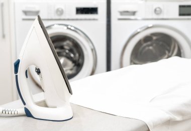 Çamaşır odasında beyaz gömlekli ütü masası