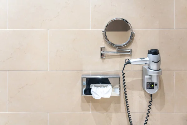 鏡とペーパータオル付きのホテルの壁にモダンな電気ヘアドライヤー — ストック写真