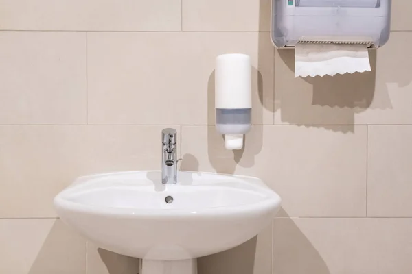 Sink next to soap dispenser pump and paper towel dispenser — Stock Photo, Image