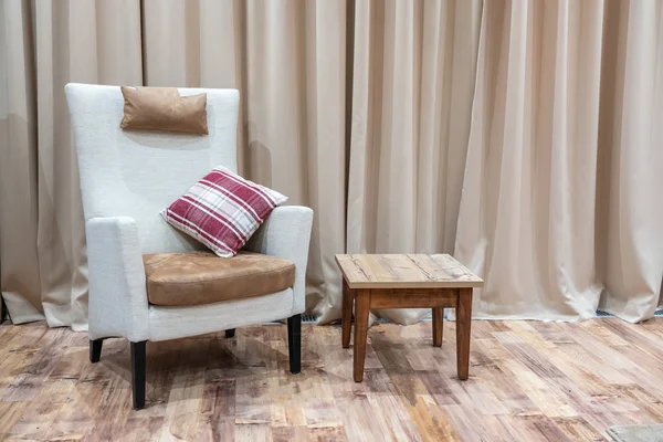 Интерьер современного гостиничного номера с креслом и деревянным журнальным столиком — стоковое фото