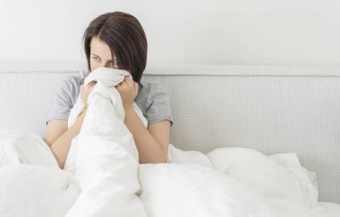 Üzgün, genç, esmer kadın evinde oturmuş fotokopi çekiyordu.