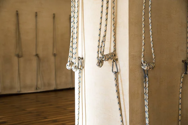 空のスタジオの壁に吊るされたヨガロープ。イエンガー｜ヨガ — ストック写真