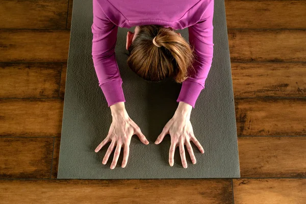 Young woman in yoga pose on mat, view from above — Stock Photo, Image